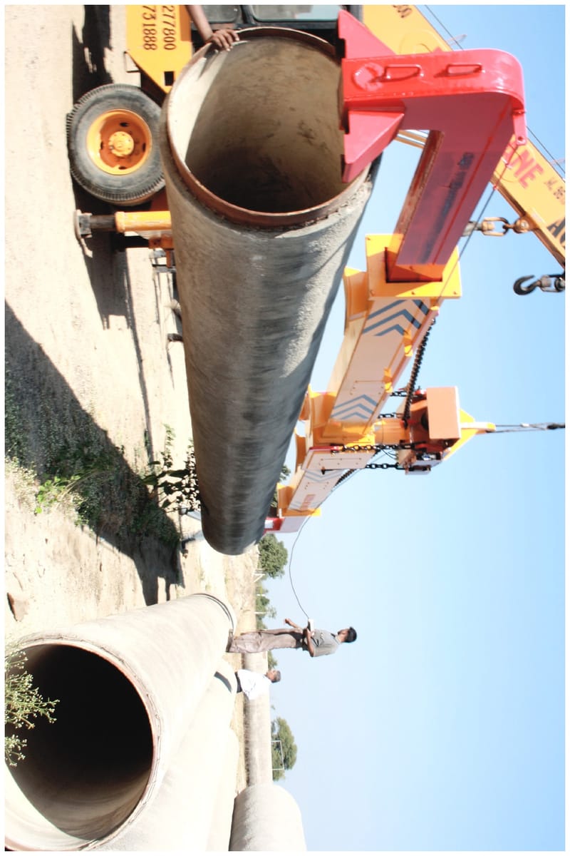Pipe lifting sling engaging a length of pipe for crane transport