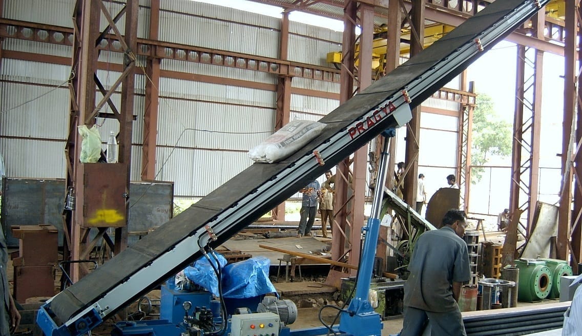 Blue inclined belt bag stacker with its boom raised and its drive unit at the foot, in the works